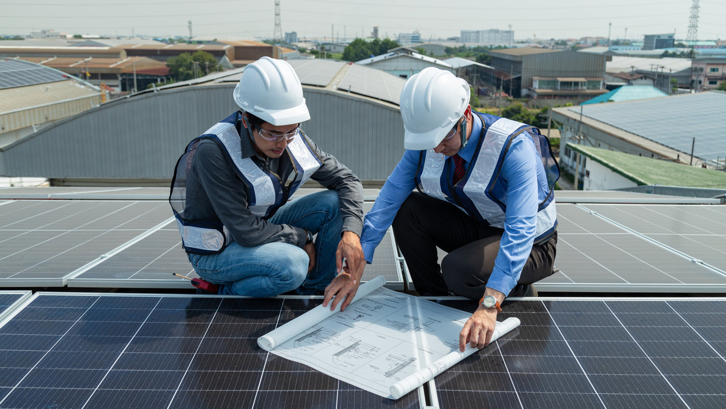 Rooftop PV installers reviewing plan.